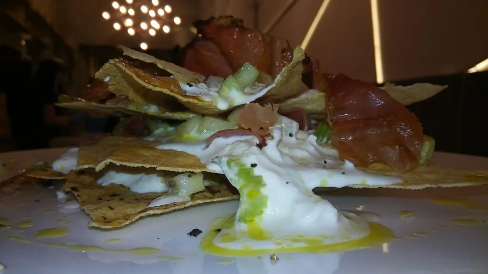 Millefoglie di pane carasau con stracciatella e speck croccante.